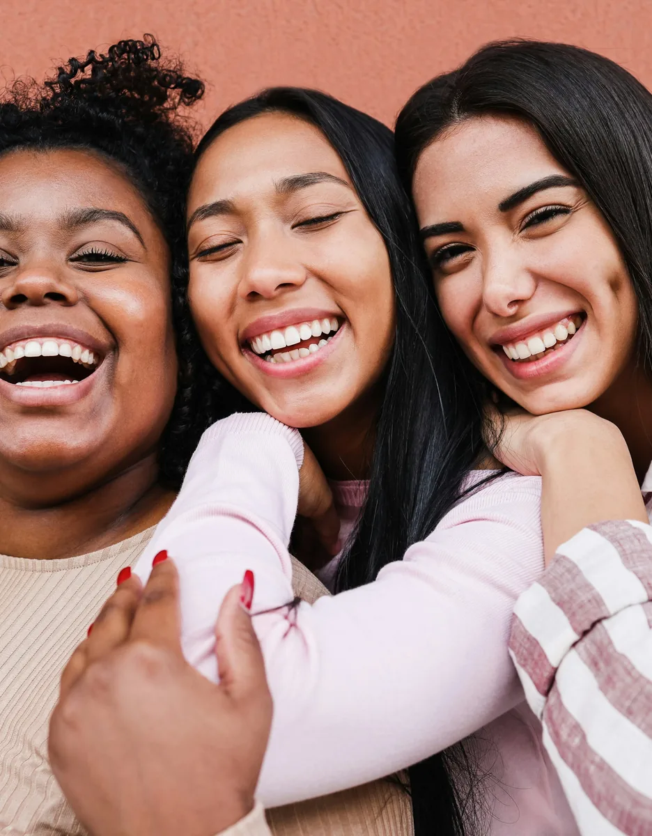 Three smiling women standing together